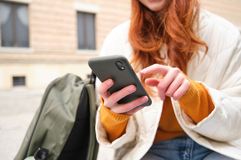 Woman using her iPhone to access social media content