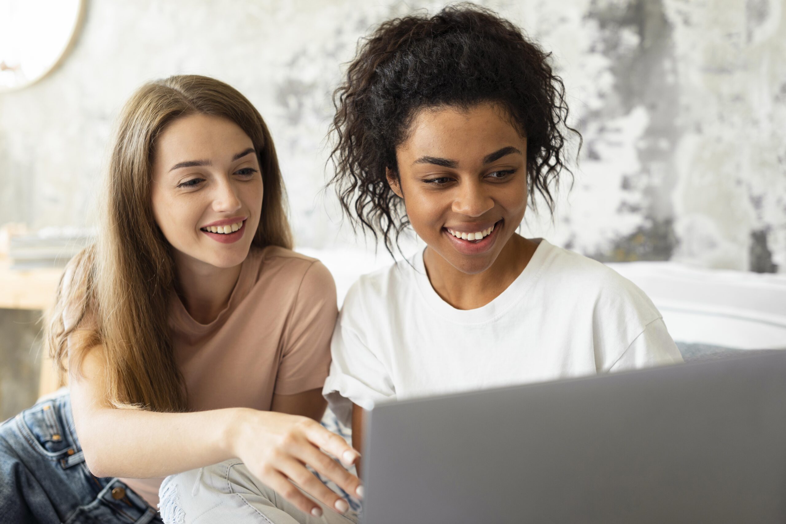 A photo of two women using a laptop to access an NWA website online.